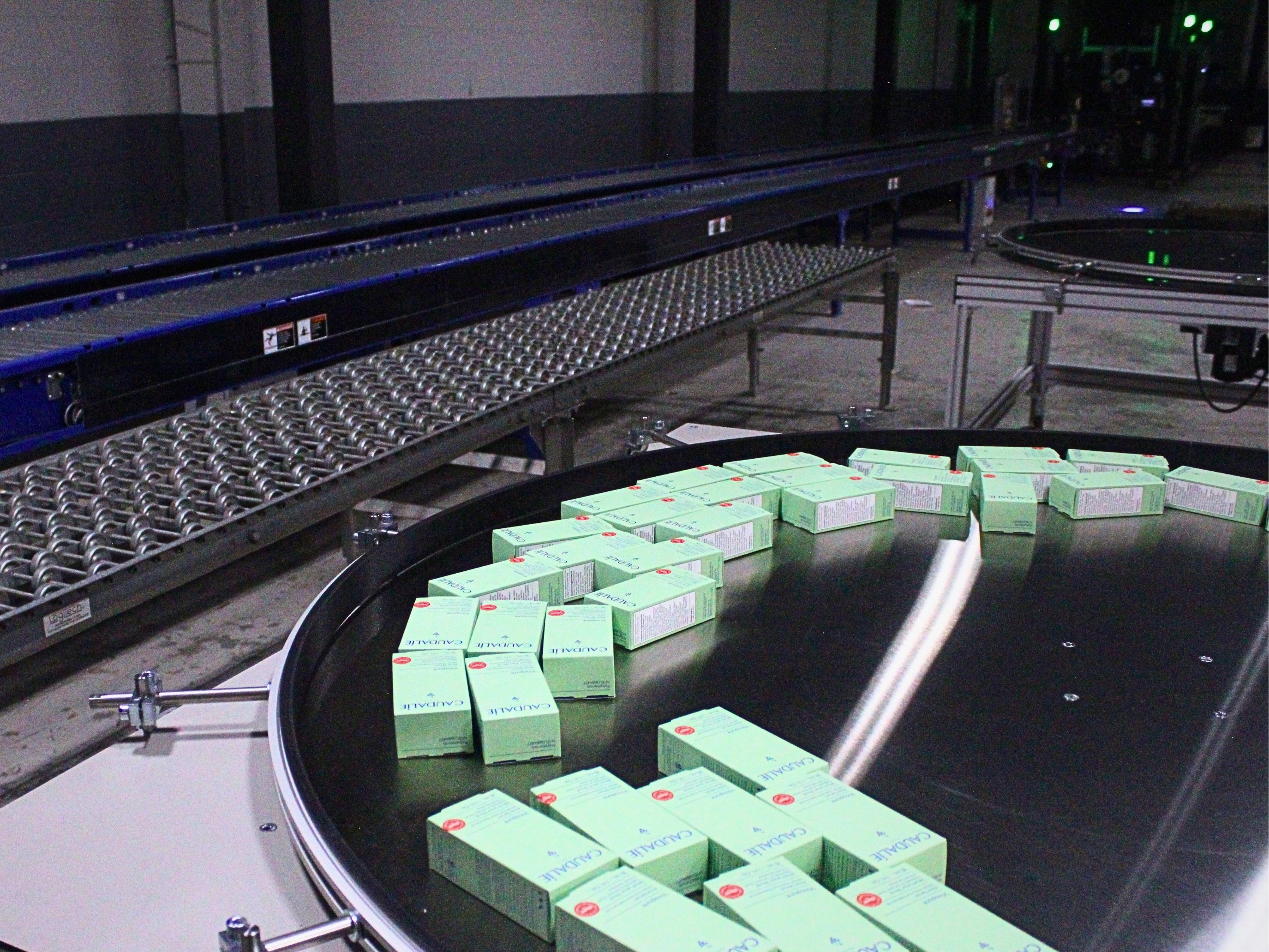 Packaged Caudalie products moving around an accumulation table