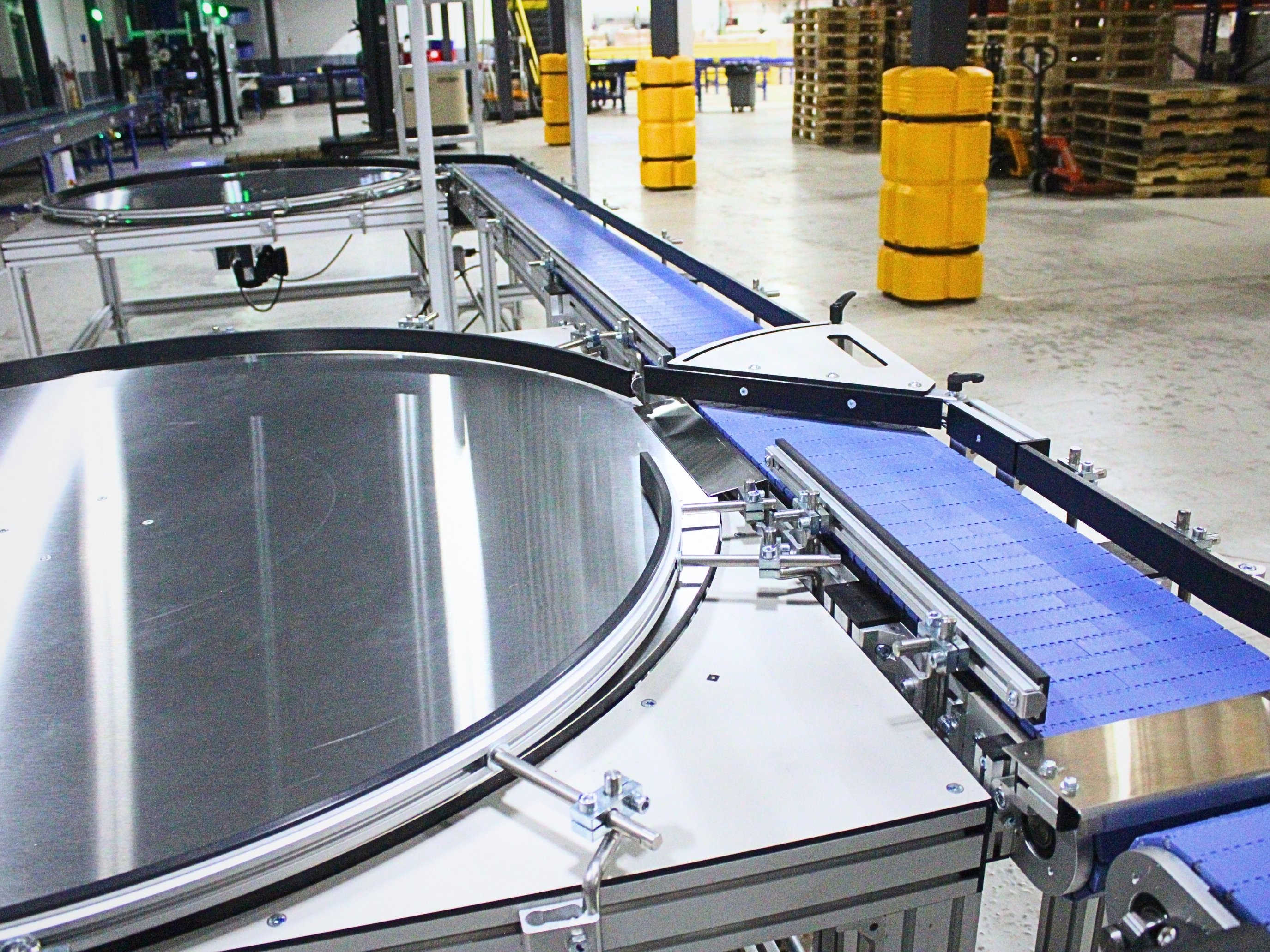 Circular accumulation table connected to a blue modular belt conveyor