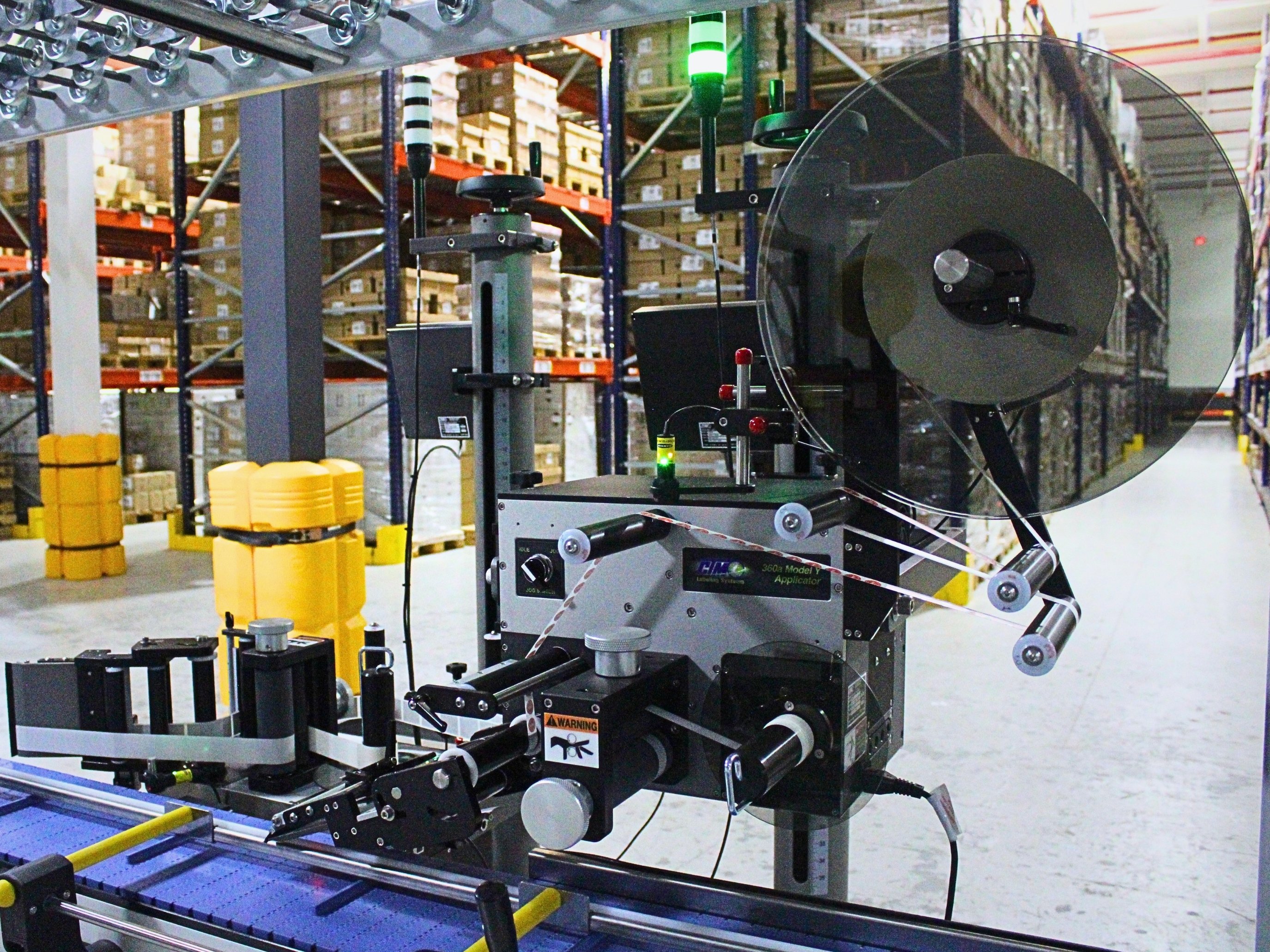 Automatic label applicator beside Caudalie’s product conveyor