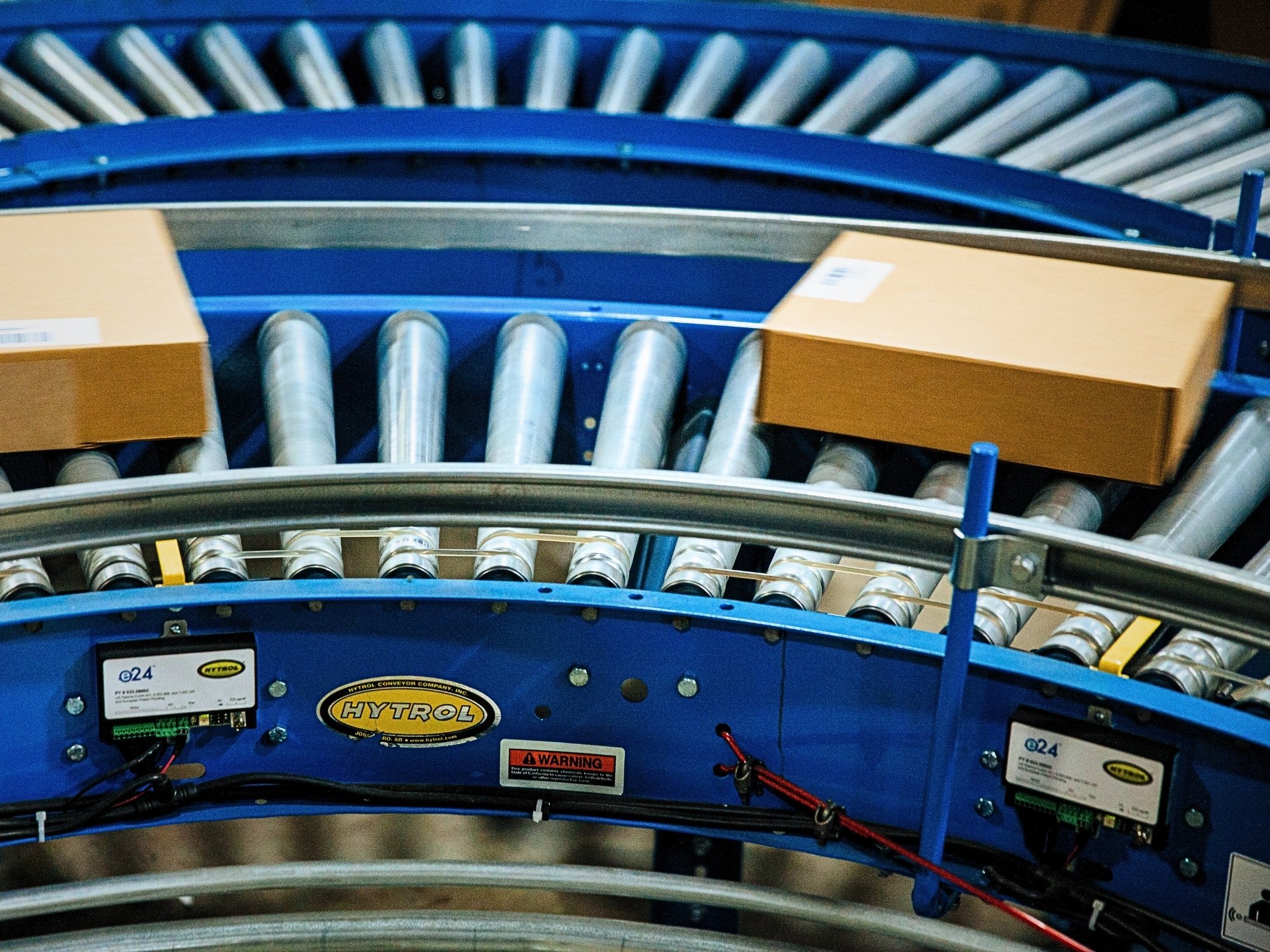 Shipping cartons following a curved Hytrol roller conveyor to change direction through the system.