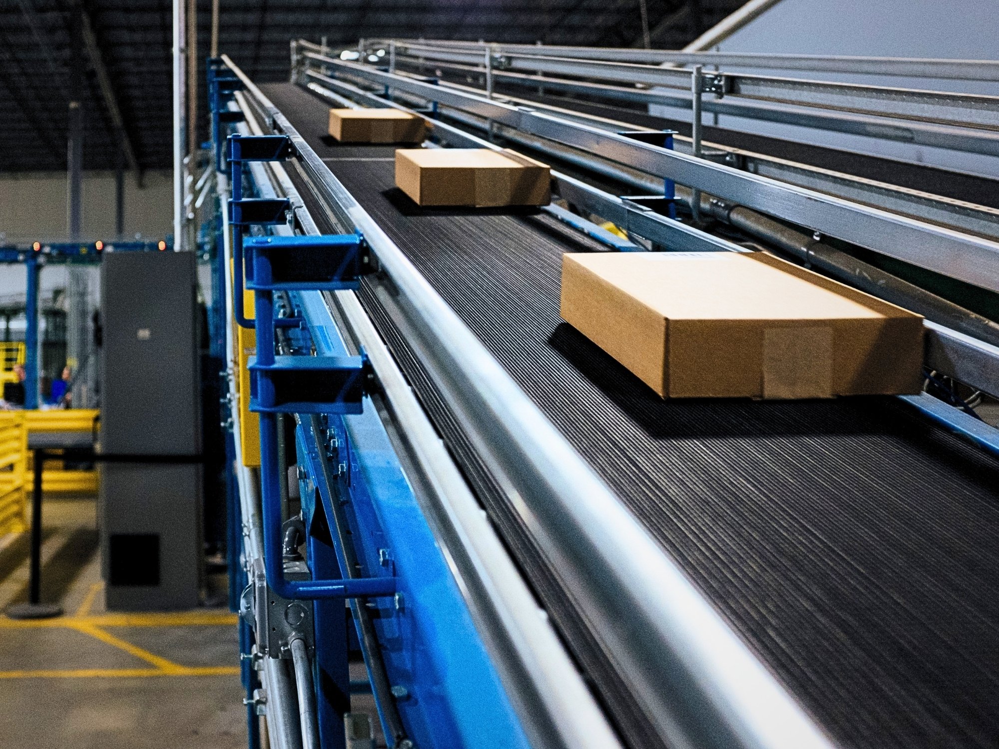 Spaced shipping cartons on an inclined belt conveyor connecting different conveyor elevations