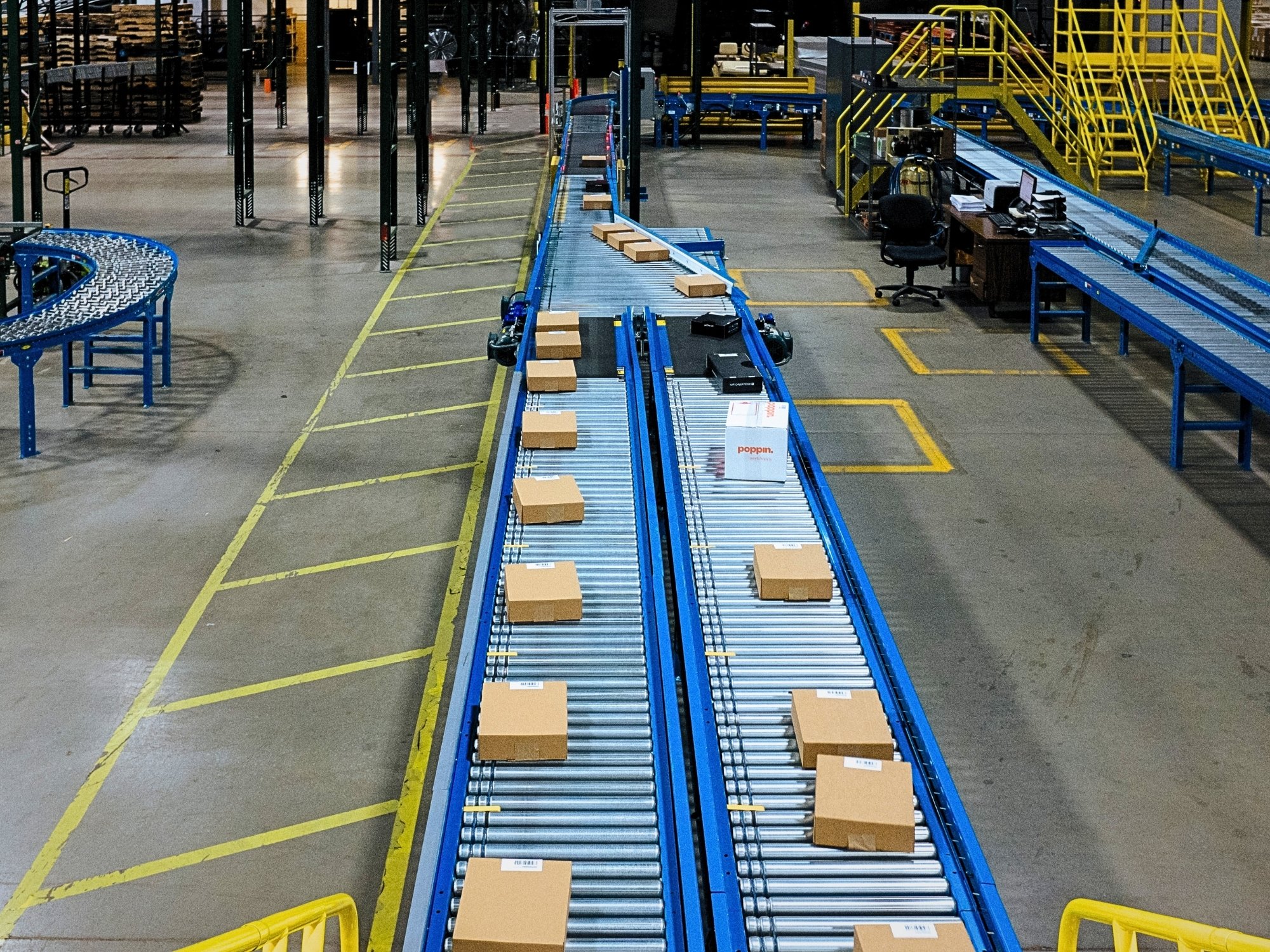 Overhead view of cartons spaced along parallel roller conveyor lanes in the fulfillment area