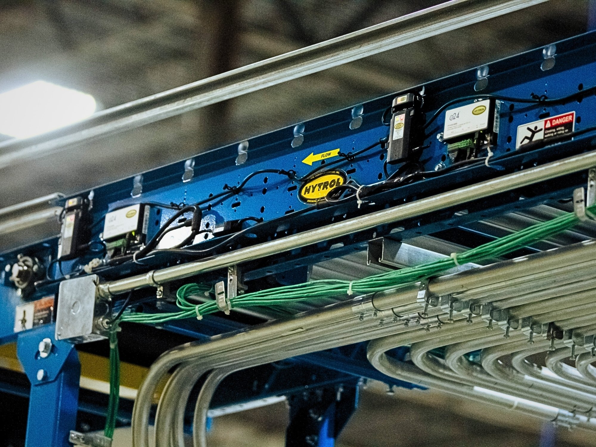Close-up of conveyor-mounted control modules and wiring used to coordinate roller conveyor zones